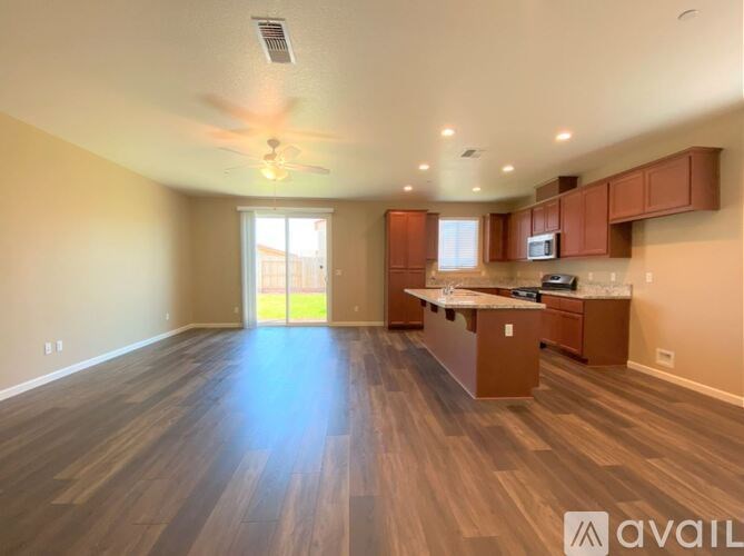 A spacious kitchen and living room with wooden flooring and modern appliances.