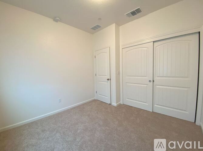 A room with two doors and a carpeted floor.