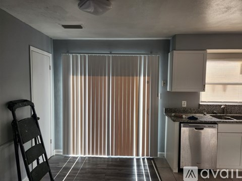 A kitchen with a stainless steel dishwasher and a wooden ladder.