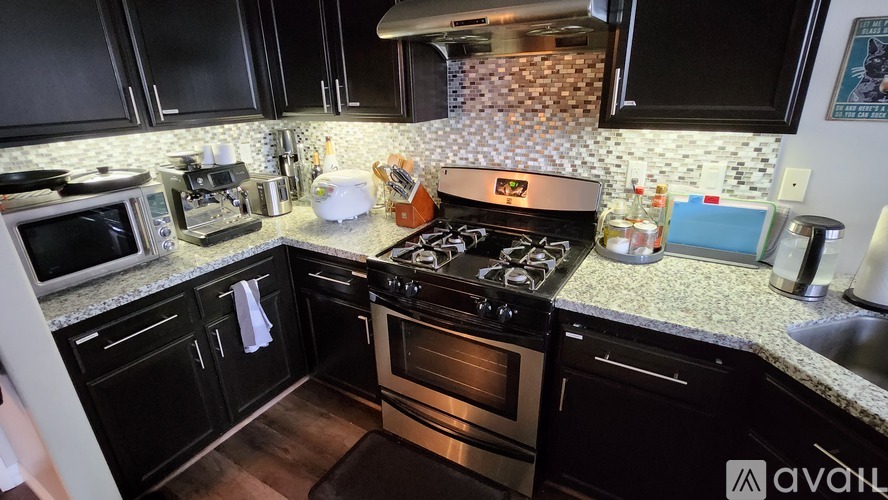 A kitchen with black cabinets and a black stove top.
