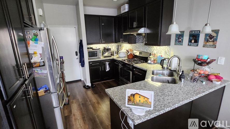 A kitchen with a refrigerator, sink, and cabinets.