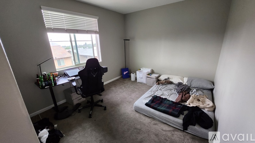 A bedroom with a bed, desk, and chair.