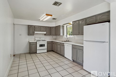 A kitchen with white appliances and brown cabinets.