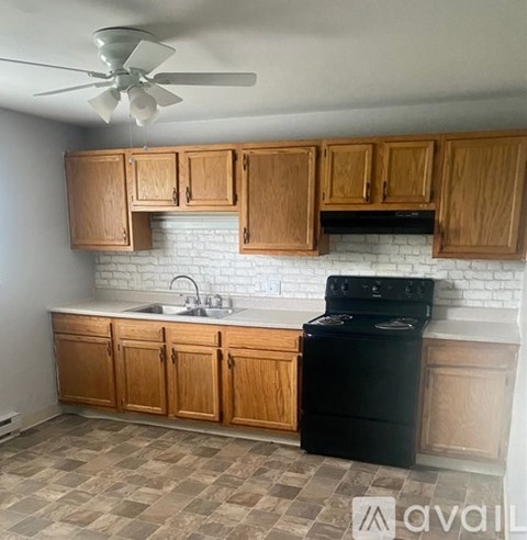 A kitchen with wooden cabinets and a black stove top oven.