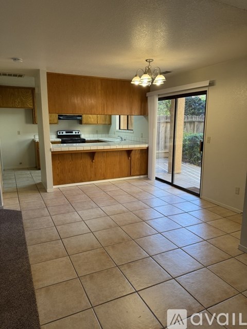 A kitchen with wooden cabinets and a tiled floor.