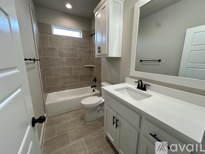 A bathroom with a toilet, sink, and tub.