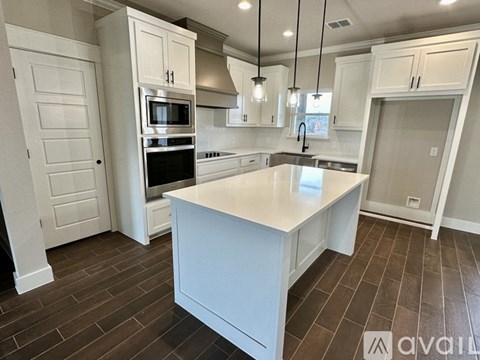 A kitchen with white cabinets and a large island.