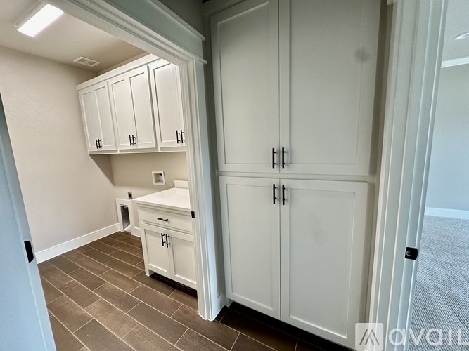A kitchen with white cabinets and a tile floor.