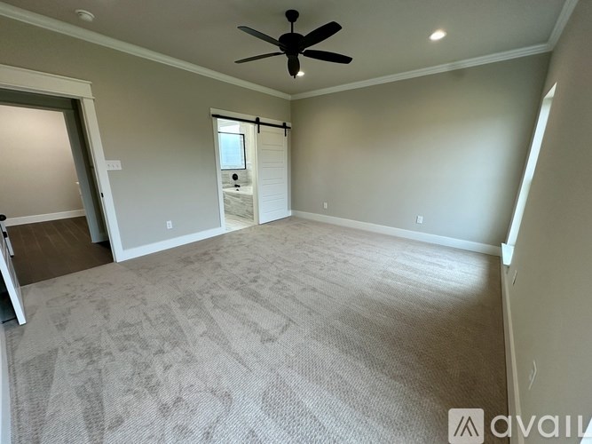 A room with a ceiling fan and carpeted floor.