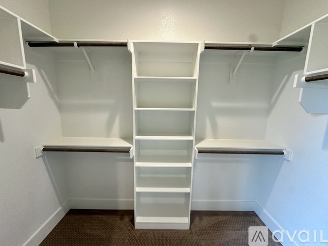 A white closet with shelves and drawers is available.