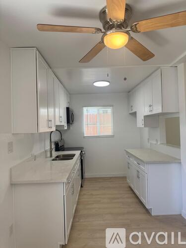 A kitchen area with a white door and a tiled floor.