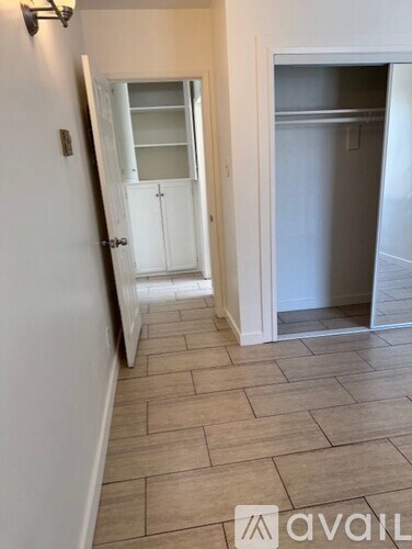 A kitchen area with a white door and a tiled floor.