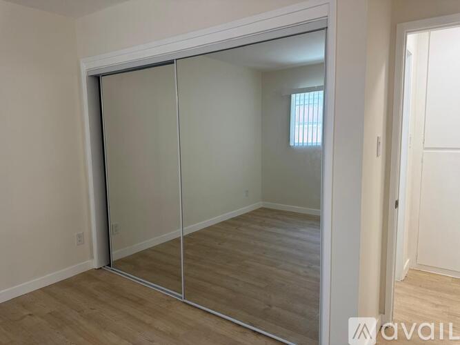 A white door is open to a bathroom with a tiled shower.