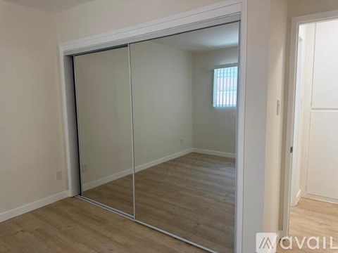 A white door is open to a bathroom with a tiled shower.