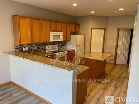 A kitchen with granite countertops and wooden cabinets.