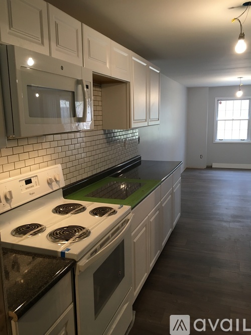 A kitchen with white cabinets and a rug on the floor.