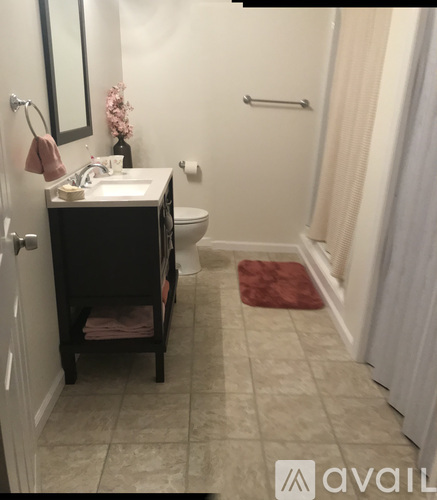 A bathroom with a toilet, sink, and a mirror.