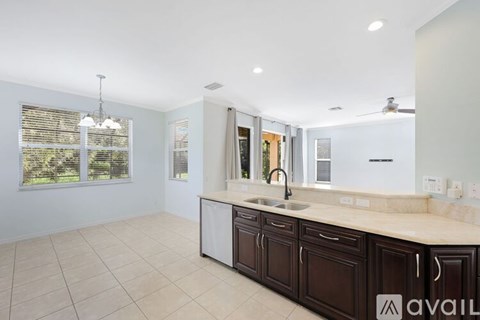 A kitchen with brown cabinets and a marble countertop.