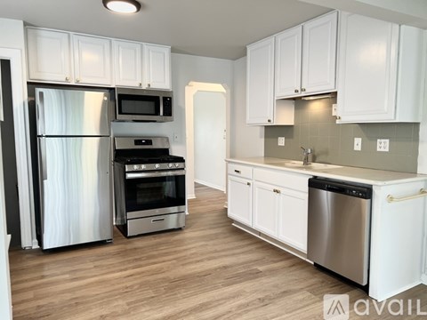 A kitchen with white cabinets and stainless steel appliances.