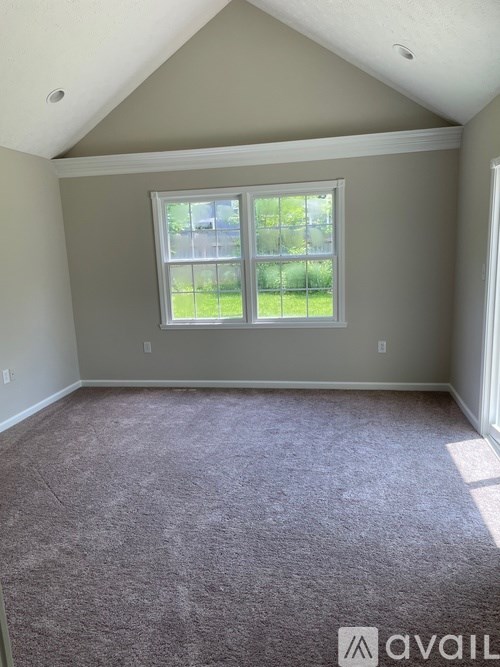 A room with a carpeted floor and a window.