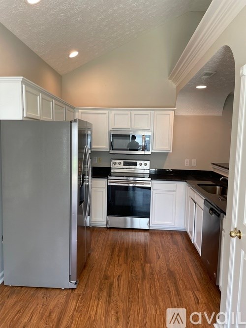 A kitchen with a refrigerator, stove, and oven.