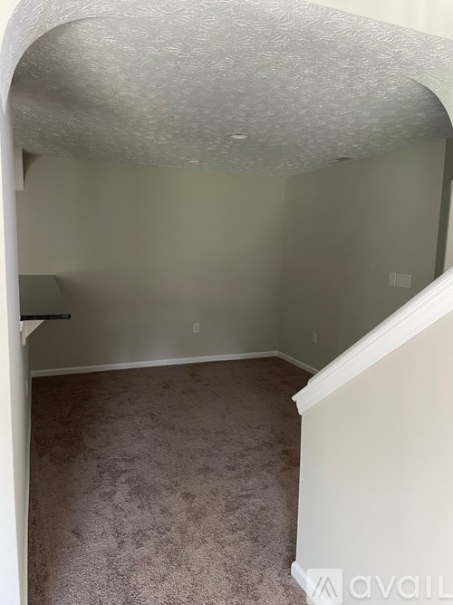 A room with a carpeted floor and a corner where a wall meets the ceiling.