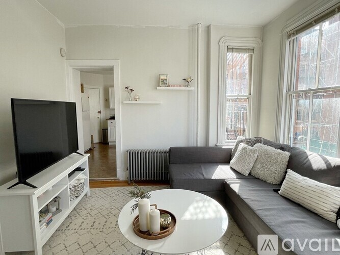 A living room with a grey couch and a white coffee table.