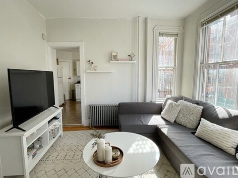 A living room with a grey couch and a white coffee table.