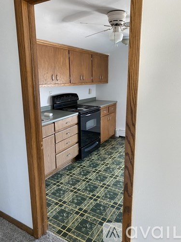 A kitchen with wooden cabinets and a black stove top oven.