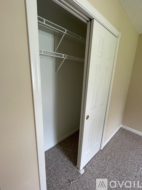 A white door with a white interior is open to a carpeted floor.
