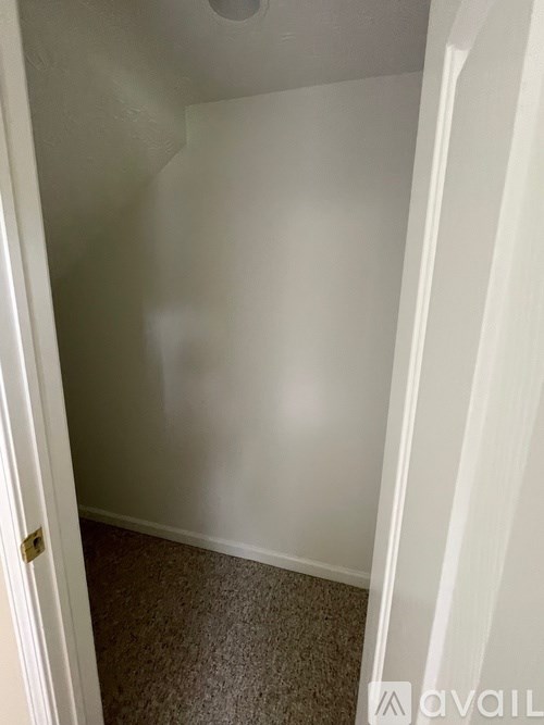 A small, empty room with a carpeted floor and white walls.