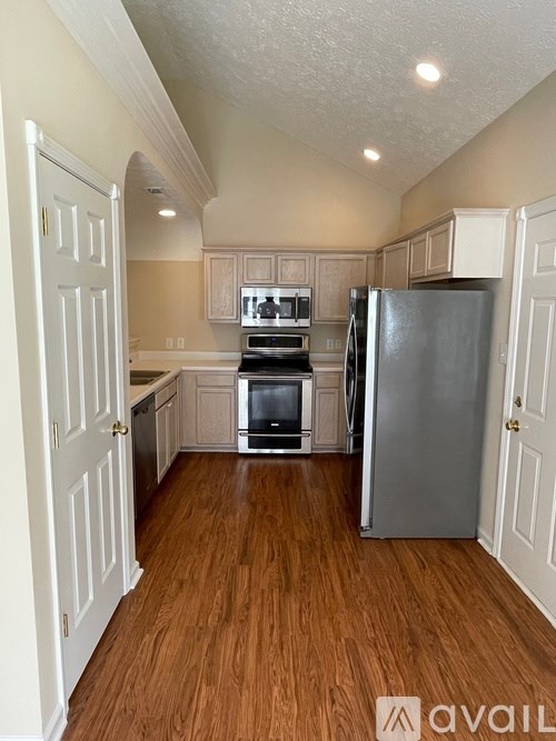 A kitchen with a refrigerator, oven, and microwave.