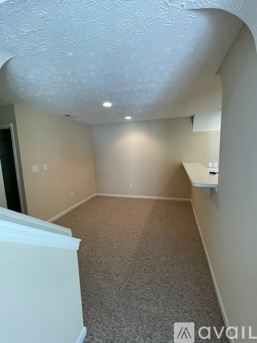 A room with a carpeted floor and a white ceiling.