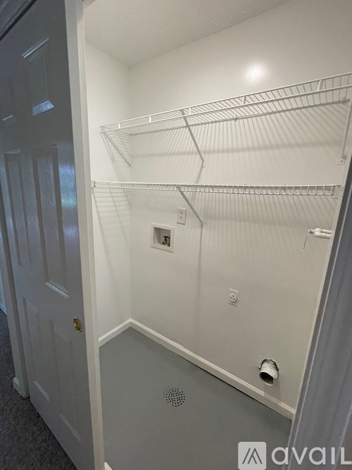 A white closet with shelves and a door.