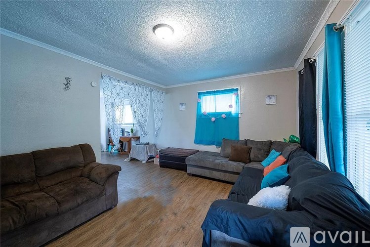 A living room with a brown couch and a grey sofa.