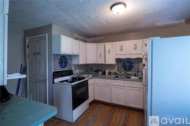 A kitchen with a white stove and cabinets.