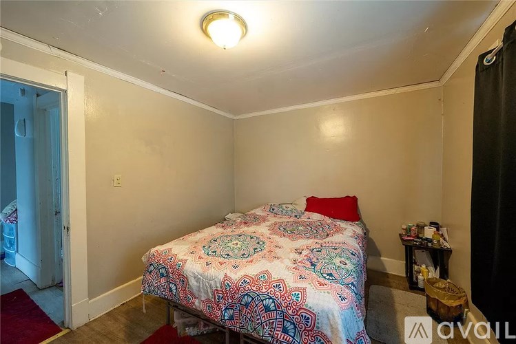 A bedroom with a bed and a red pillow.