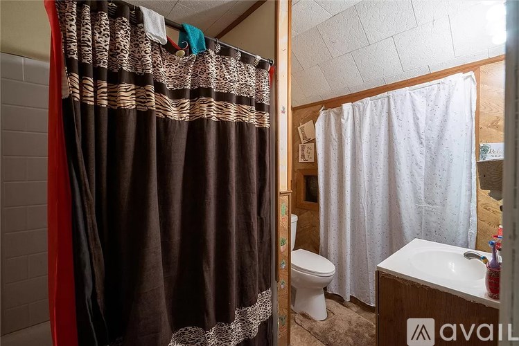 A bathroom with a brown shower curtain and a white sink.