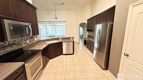 A kitchen with brown cabinets and a black countertop.
