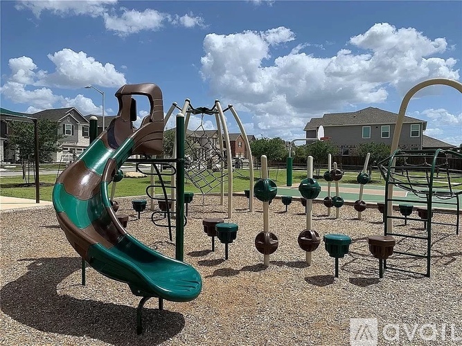A playground with a green slide and various other play equipment.