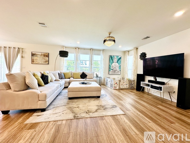 A living room with a white couch, a coffee table, and a flat screen TV.
