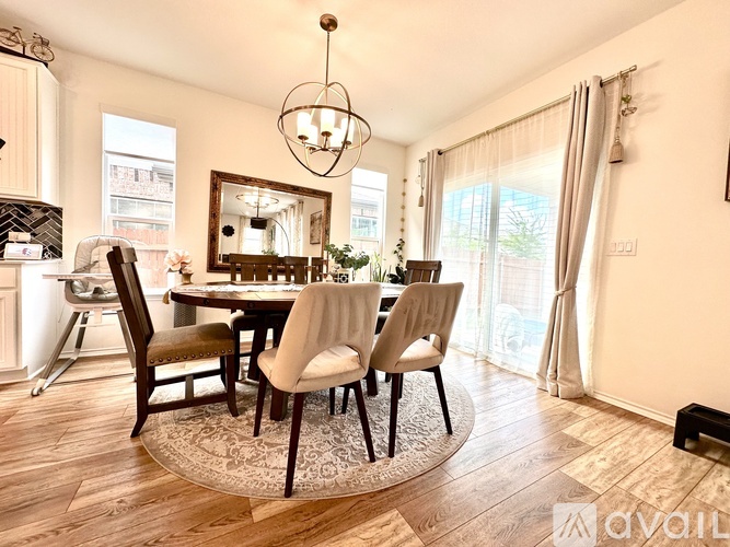 A dining room with a round table and chairs.