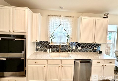 A kitchen with white cabinets and a black oven.