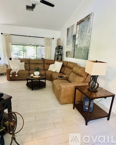 A living room with a brown sofa and a black coffee table.