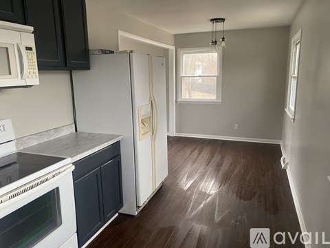 A kitchen with a white refrigerator and black cabinets.