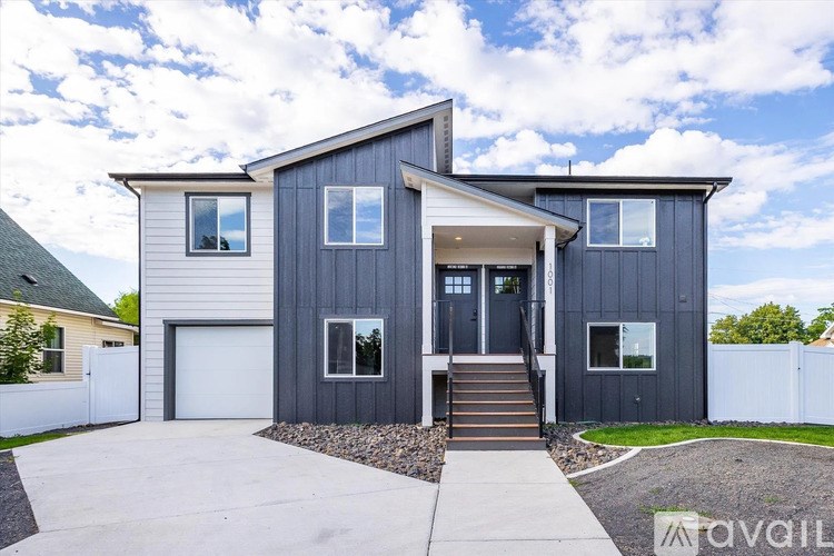 A modern two-story house with a garage and a front porch.