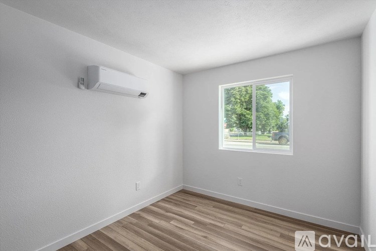 A room with a window and a wall-mounted air conditioner unit.