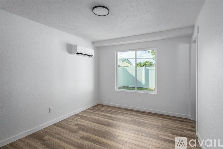 A room with a window and a wall-mounted air conditioner unit.