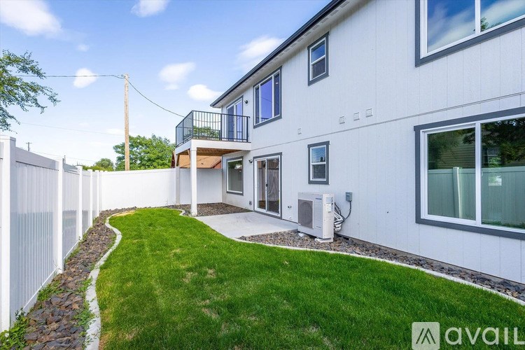 A white house with a green lawn in front.