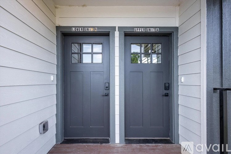 Two doors with windows and a sign above them.